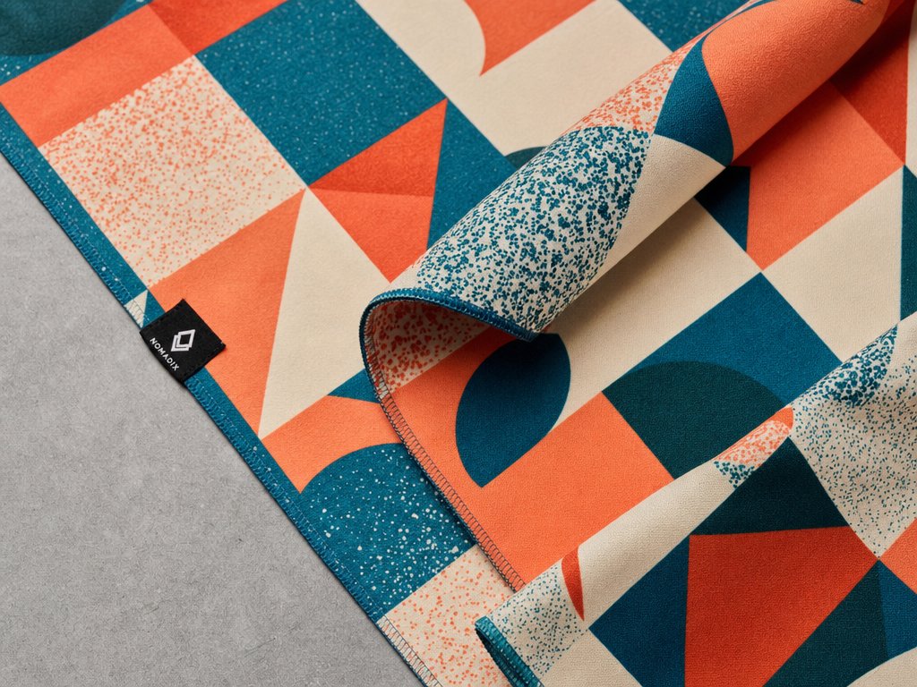 Vibrant all-over geometric sublimation print on microfiber sports towel terracotta and teal pattern